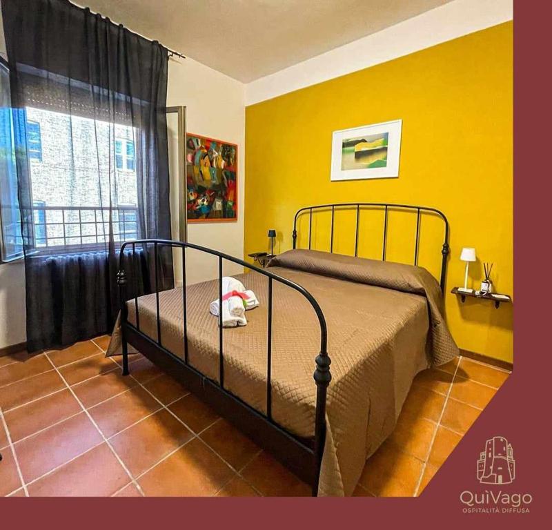 1 dormitorio con cama y pared amarilla en QuiVago, en Ripe San Ginesio
