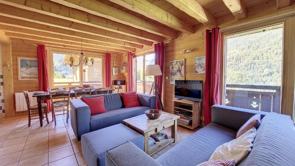 una sala de estar con 2 sofás azules y una mesa. en Chalet MON FRERE en Le Biot