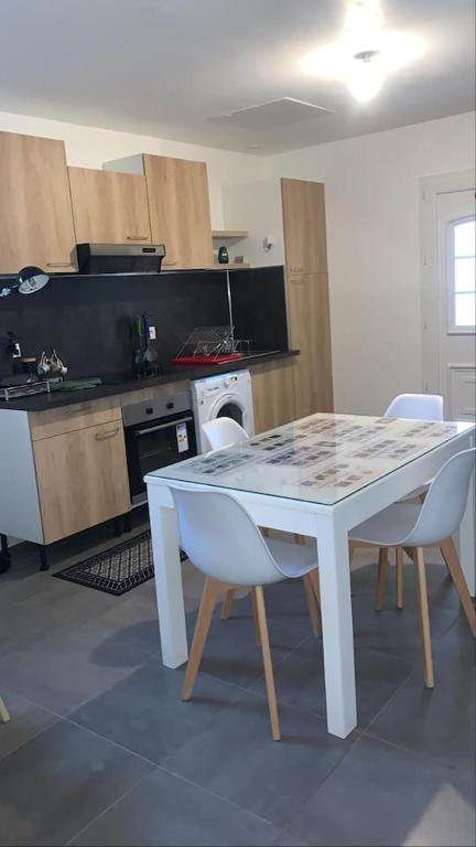 une cuisine avec une table blanche et des chaises dans l'établissement MAISON DU BONHEUR, à Lesparre-Médoc