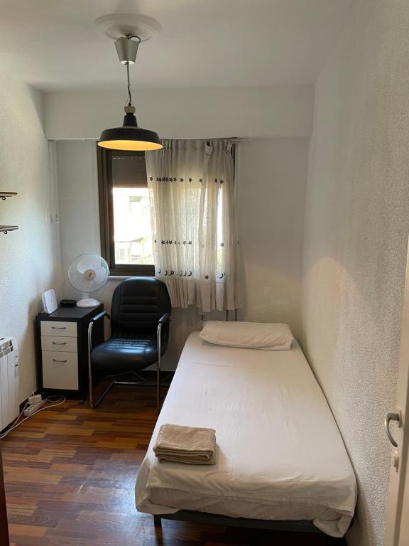 a bedroom with a bed and a desk and a chair at Como en casa in Barakaldo