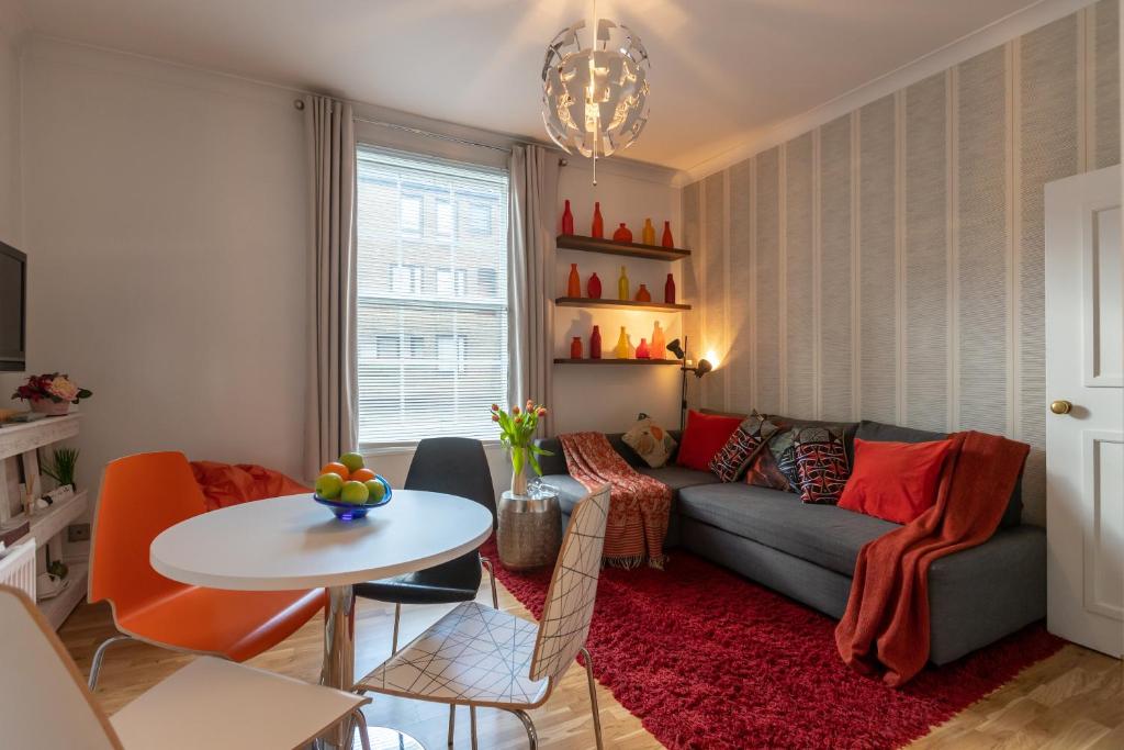 a living room with a couch and a table at Experience Vibrant Covent Garden - The Wanderlust by SmartStays in London