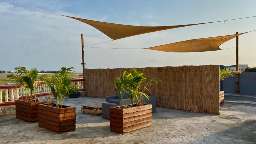 a patio with palm trees and a fence at Home4u Fidji F2 in Cotonou