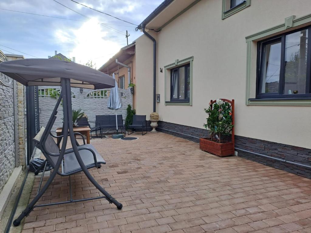 patio z parasolem, stołem i krzesłami w obiekcie Mareto House w mieście Turda