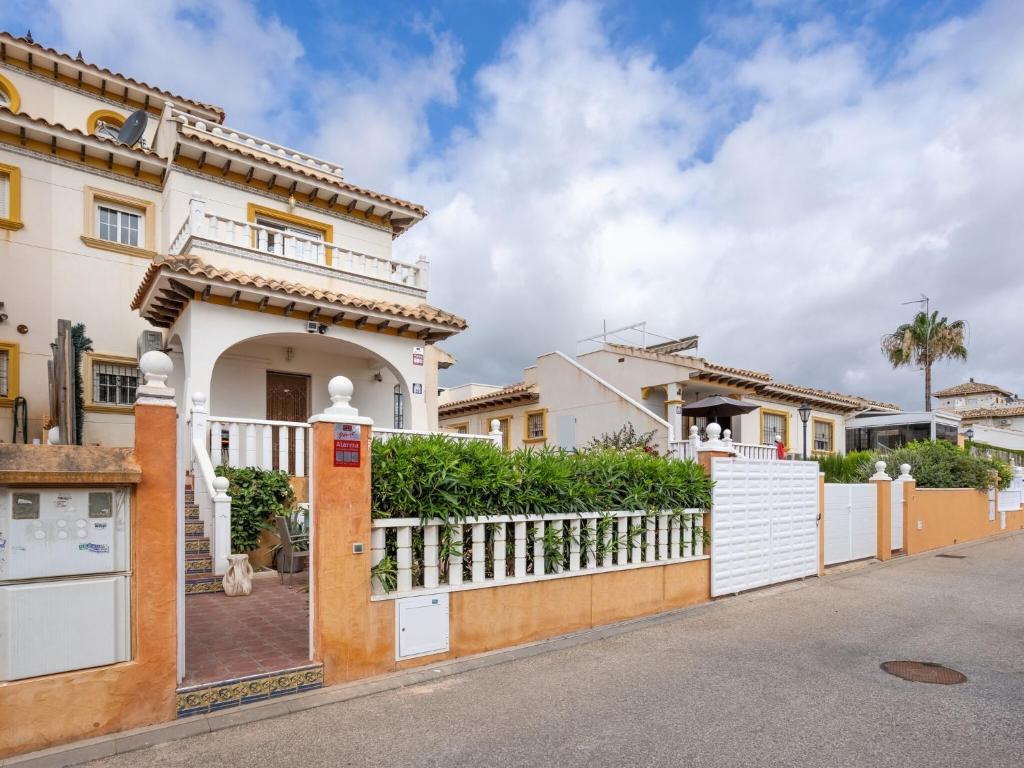 una casa con una puerta blanca y una valla en Stunning holiday home in Cabo Roig not far from the beach en Cabo Roig