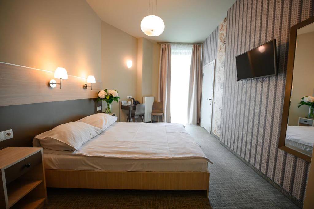 ein Hotelzimmer mit einem Bett und einem TV in der Unterkunft Hotel Kazimierz III in Krakau