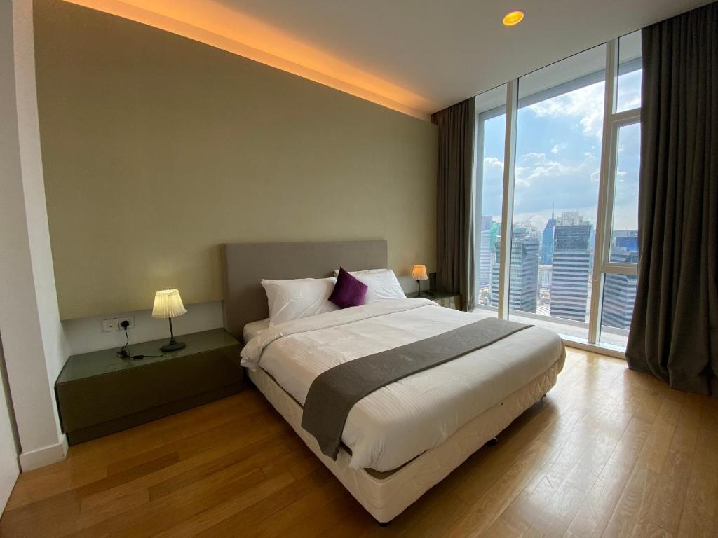een slaapkamer met een groot bed en een groot raam bij KLCC Sky Villa Suites Platinum in Kuala Lumpur