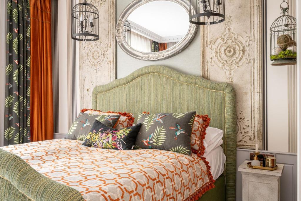 a bedroom with a green bed with pillows and a mirror at Apartament Drozdówka Kaszelewskiego 7 APARTZAKOP in Zakopane