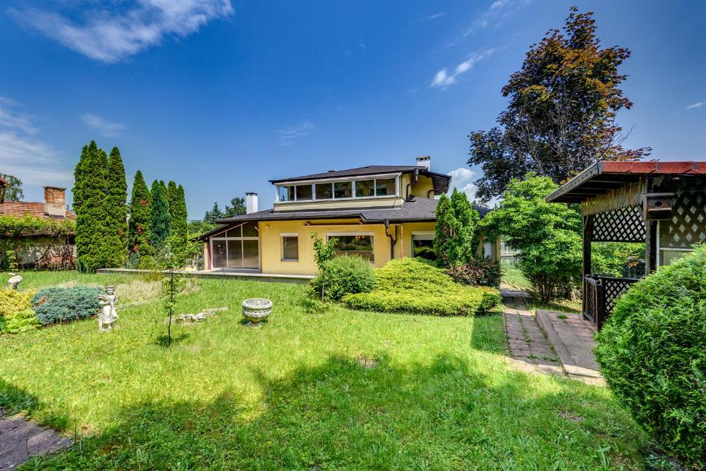 a large yellow house with a yard at Villa Boyana City & Relax in Sofia