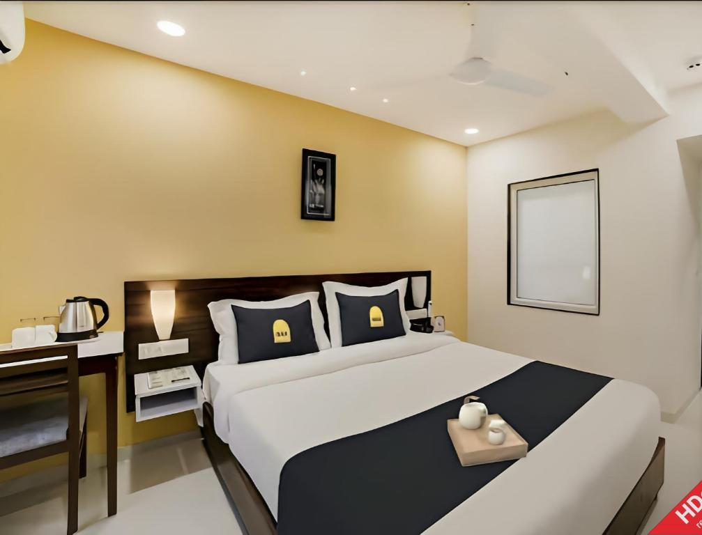 1 dormitorio con 1 cama grande y escritorio en Leo Hotel, en Ahmedabad