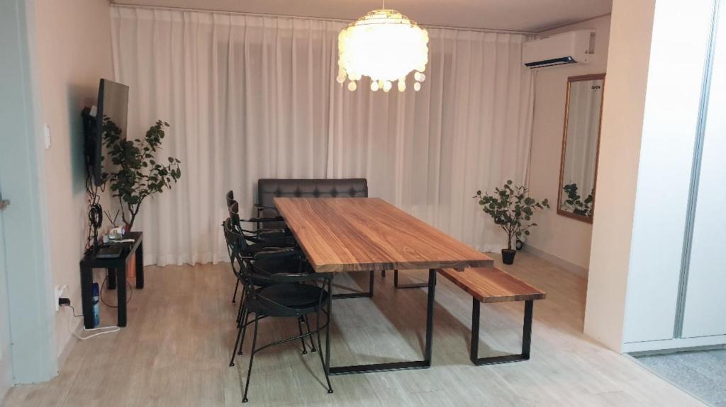 une table à manger avec des chaises et un lustre dans l'établissement Seoul Vibes, à Séoul