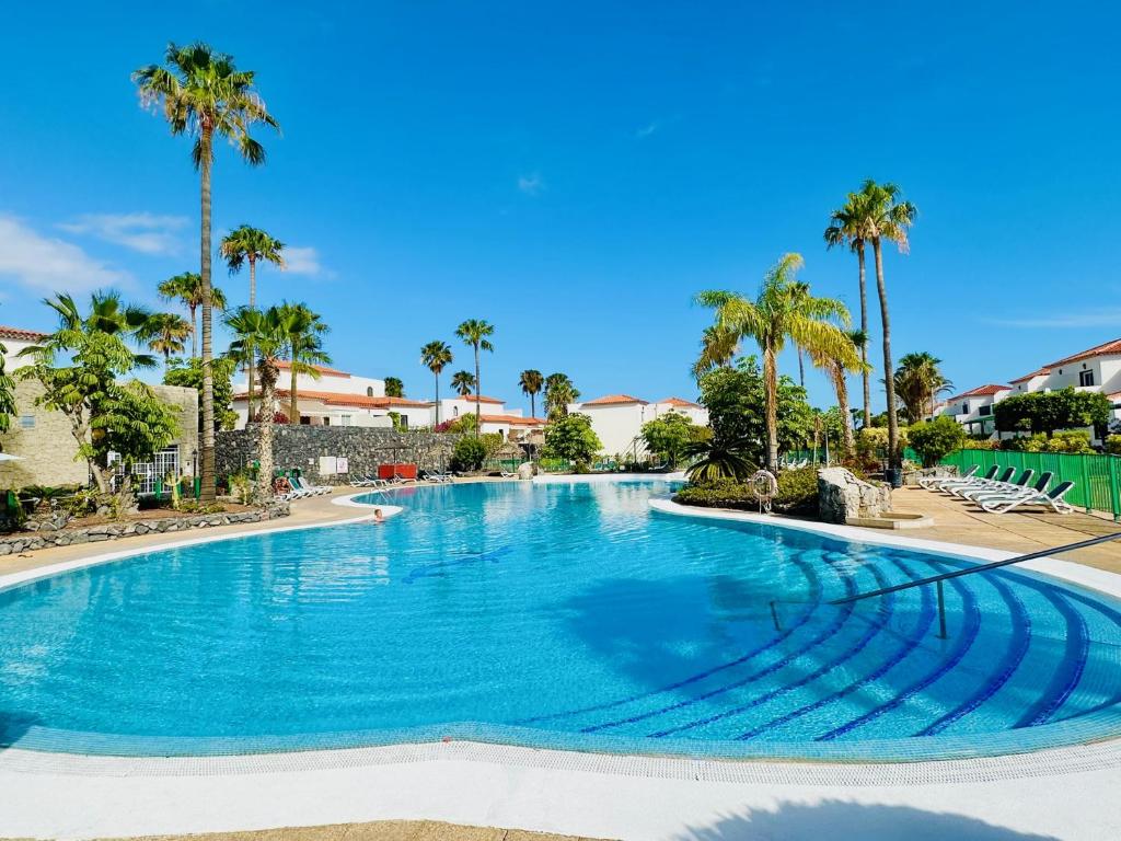 una grande piscina con palme in un resort di Tenerifehause a San Miguel de Abona