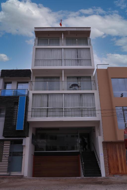 a tall building with a parking garage in front of it at Hospedaje Arenas del Mar in Ilo