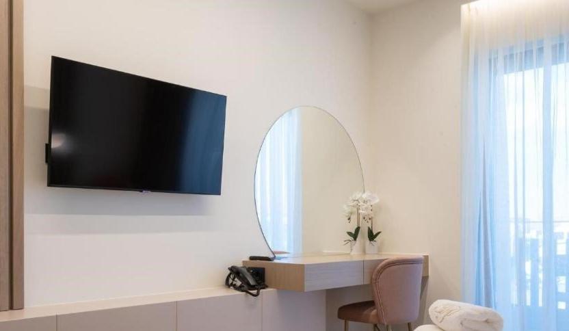 a room with a tv and a mirror on a wall at GRAND PATELLI in Myrina