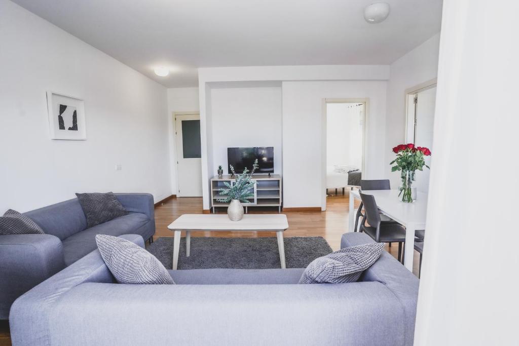 - un salon avec deux canapés bleus et une table dans l'établissement Cornisa Apartments, à Patalavaca
