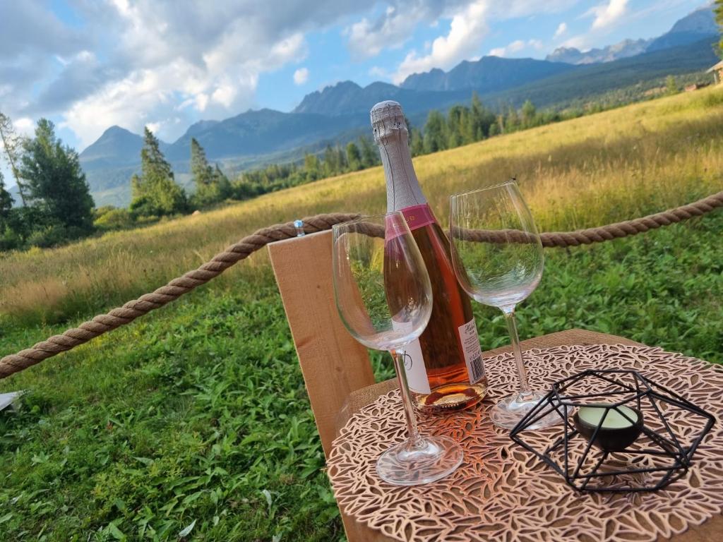 una bottiglia di vino e due bicchieri su un tavolo di Domčok pod Tatrami a Važec