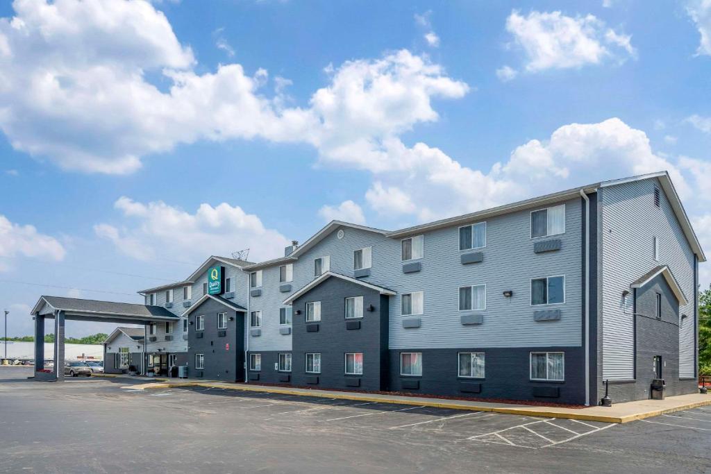 a large apartment building in a parking lot at Quality Inn & Suites Delaware in Delaware