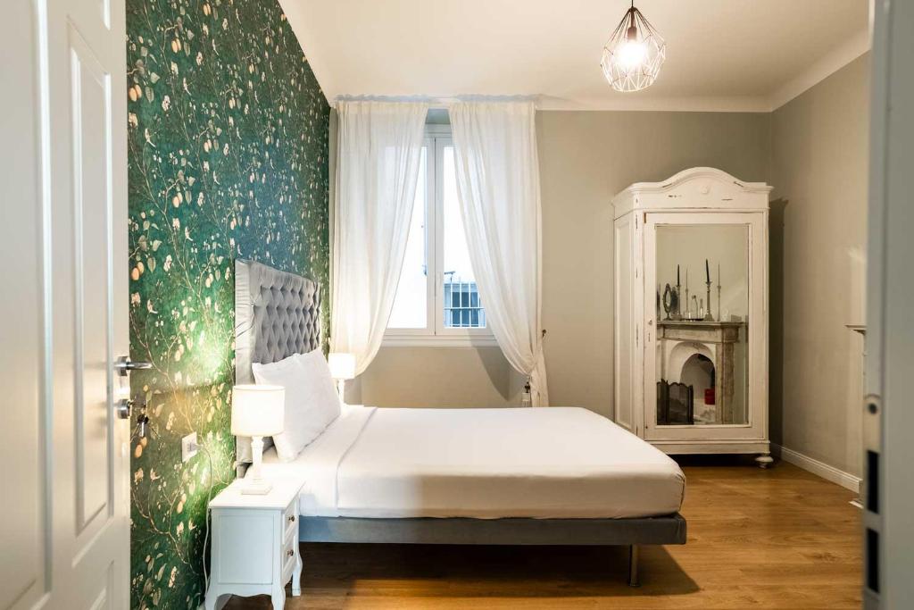 a bedroom with a white bed and a mirror at La Piazzetta Rooms & Apartments in Genoa