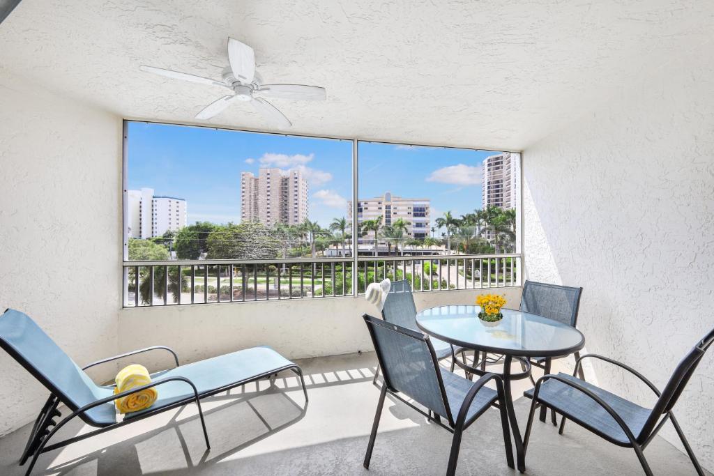 a balcony with a table and chairs and a window at Beach Club 403 in Marco Island
