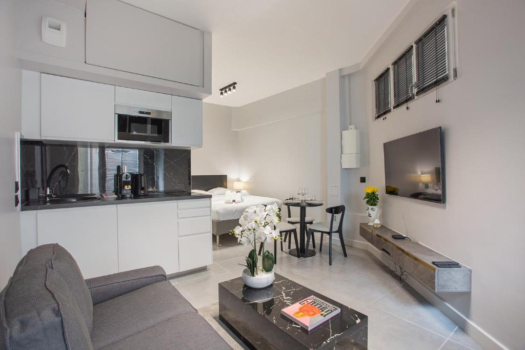 een keuken en een woonkamer met een bank en een tafel bij Residense Montmartre by Studio prestige in Parijs