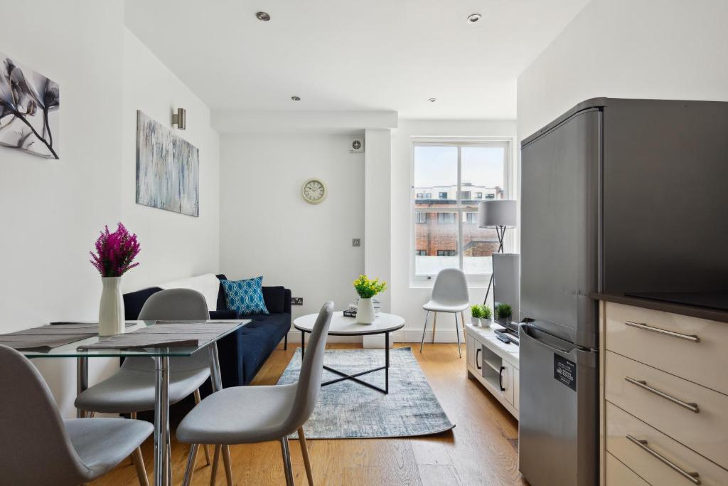 a kitchen and living room with a table and chairs at Luxury Urban Living - 1 BDR in London