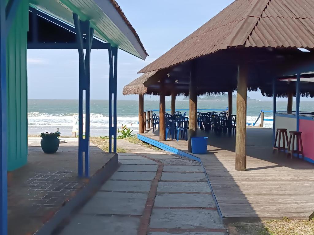 a patio with tables and chairs on the beach at Pousada Oceano Azul in Ilha do Mel
