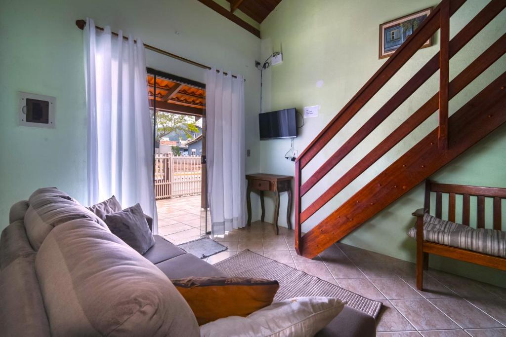 sala de estar con sofá y escalera en 2 quadras da Praia de Zimbros, 9 hóspedes RW2724, en Bombinhas