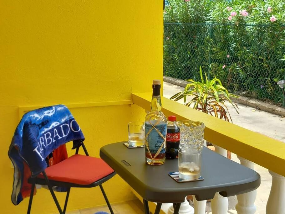 een tafel met een fles alcohol en een stoel bij Coastal View 7 Apartments 2 Bed in Christ Church