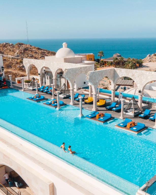 a pool at a resort with people in the water at Vista Encantada in Cabo San Lucas