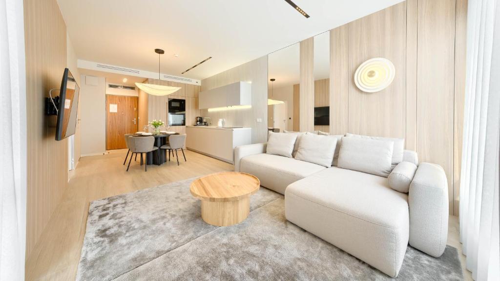 uma sala de estar com um sofá branco e uma mesa em Apartamenty Sun & Snow Olympic Park I em Kolobrzeg