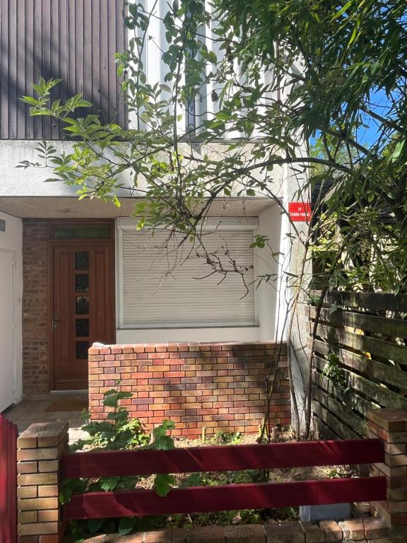 a house with a garage door and a brick wall at se: 13A rue des Touleuses Pourpre in Cergy