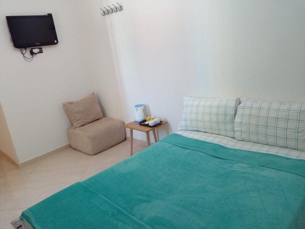 um quarto com uma cama e uma cadeira e uma televisão em Dar Said Airport em Casablanca
