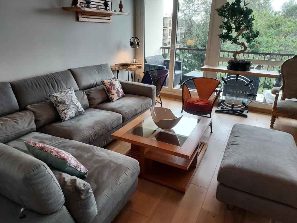 a living room with a couch and a coffee table at LES JARDINS D'ATILLY in Villecresnes