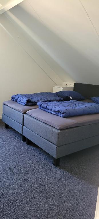 een bed met blauwe lakens in een kamer bij Vakantiehuis 6pers op park 't Broeckhuys in Ewijk groot Zwemplas in het land van Maas & Waal niet voor arbeidsmigranten in Ewijk