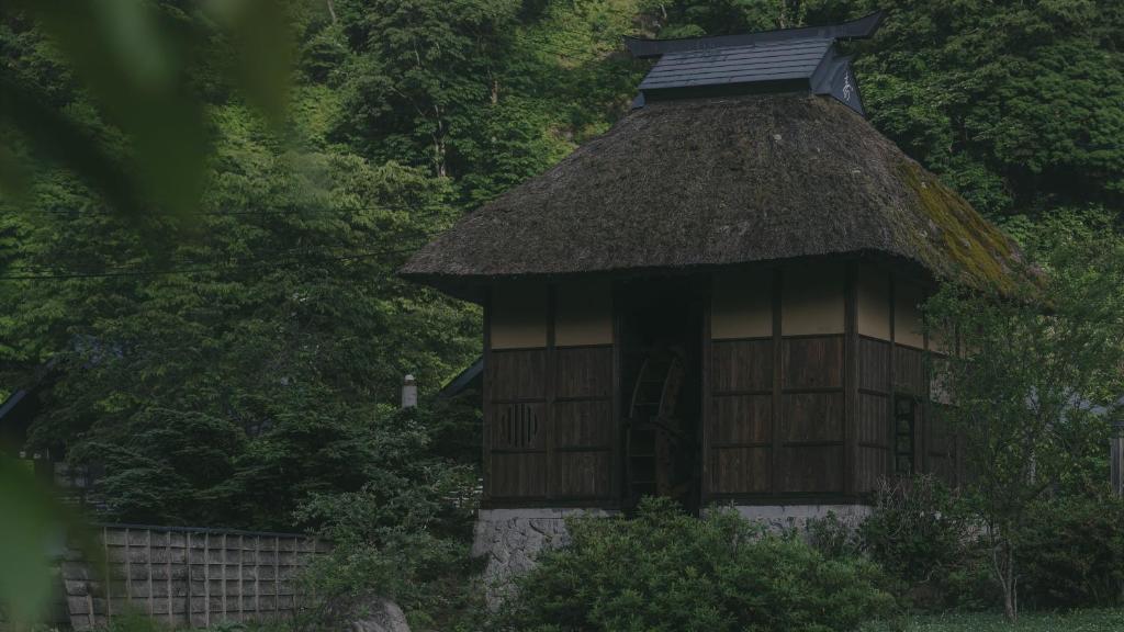 a small hut with a thatched roof at Kinasanoyu Hotel&Cottage in Nagano