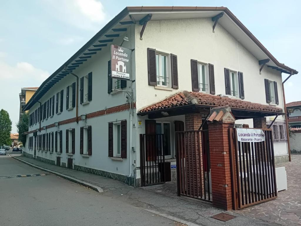 un edificio blanco con una puerta delante en Locanda Il Portone en San Colombano al Lambro