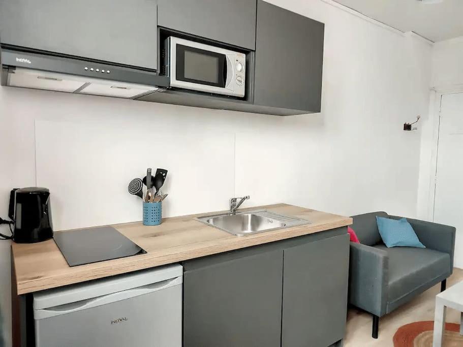 uma cozinha com um lavatório e um micro-ondas em Stud' extra Cosy 2 pers gare wifi em Saint-Quentin