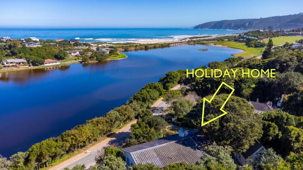 Una isla en medio de un lago con las palabras casa de vacaciones en Wilderness Holiday Home - Riverside, en Wilderness