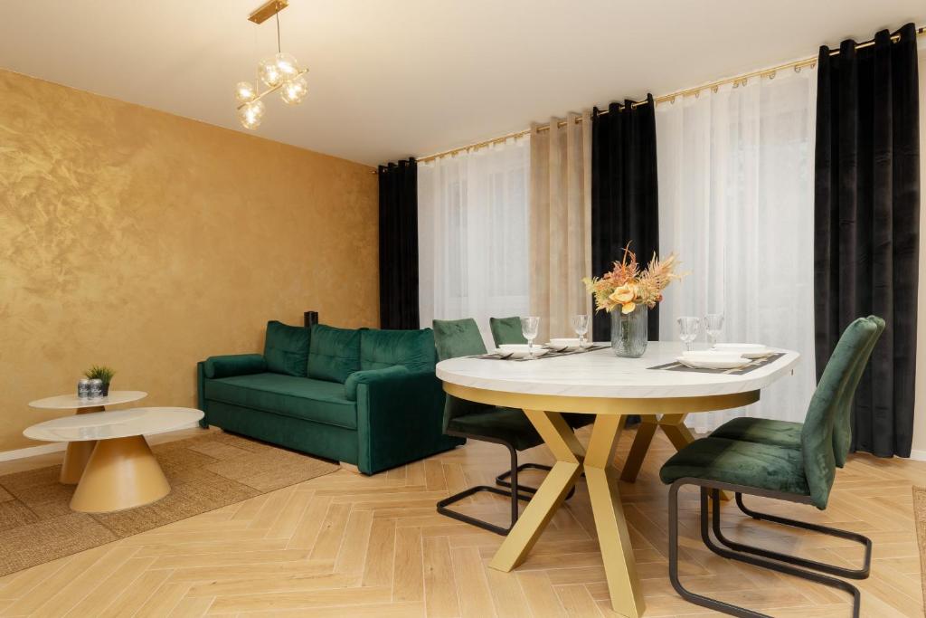 a living room with a table and a green couch at Ursus Nova Apartment with Parking by Renters Prestige in Warsaw