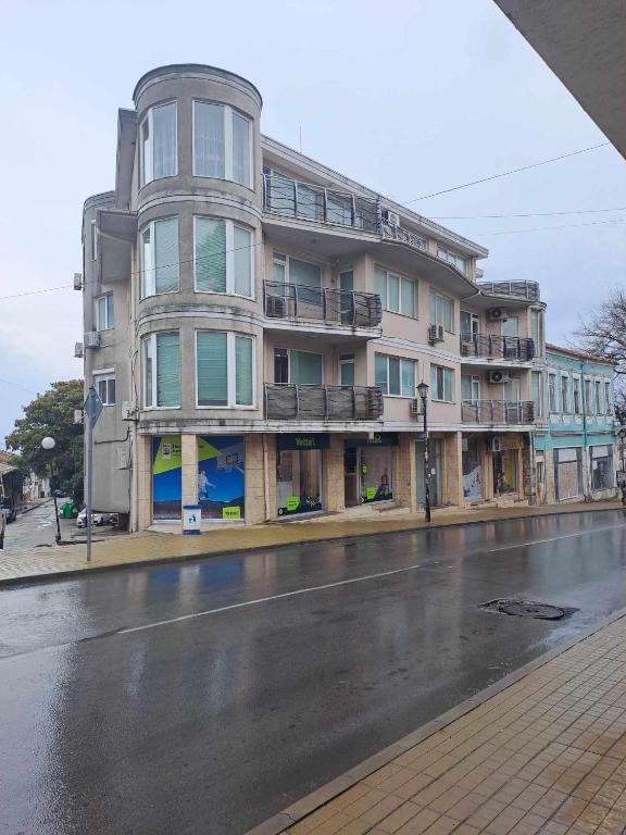 un grand bâtiment sur le côté d'une rue dans l'établissement АПАРТАМЕНТ Амира 2, à Balchik