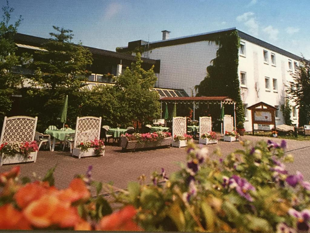 eine Gruppe von Stühlen und Tischen vor einem Gebäude in der Unterkunft Niebuhrs Hotel in Friedrichsdorf