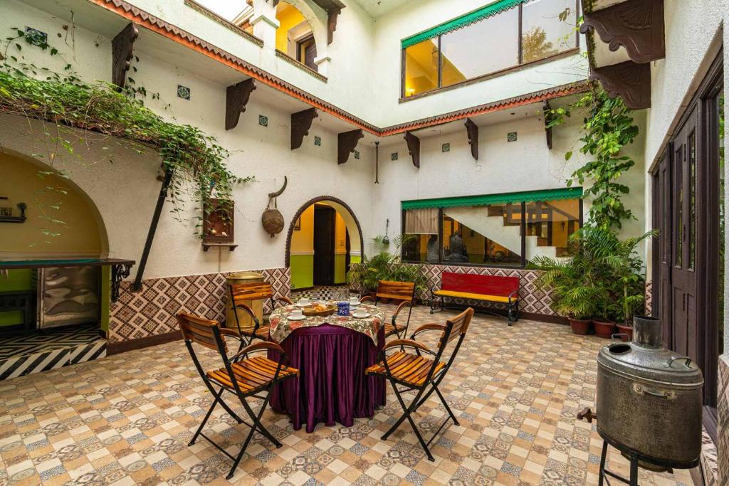 un patio con mesa y sillas en un edificio en StayVista's Courtyard House - Kanha - Villa with Private Pool, Central Courtyard & Terrace en Dhanwār