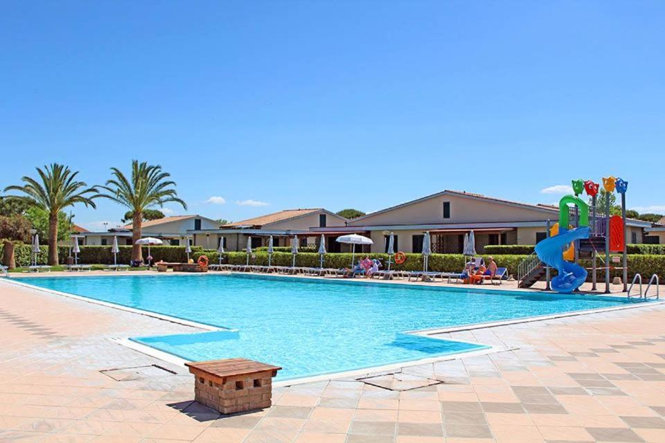una piscina in un resort con scivolo di La Cecinella Apartments a Marina di Cecina