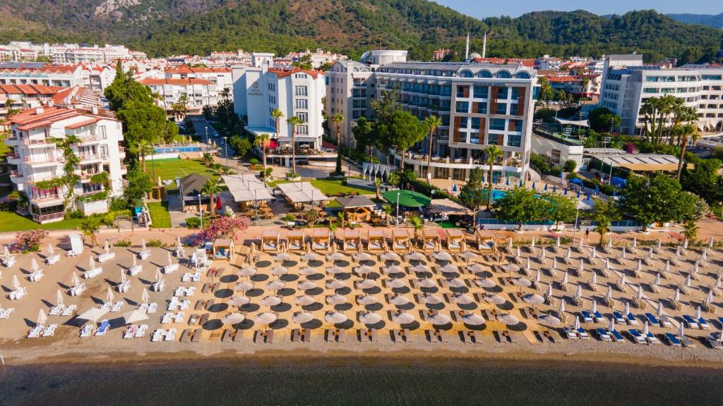 een luchtzicht op een strand met parasols en gebouwen bij Hotel Caprea in Marmaris