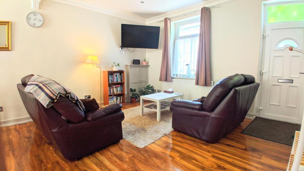 a living room with two chairs and a tv at New Holiday Let in Skipton, North Yorkshire in Skipton