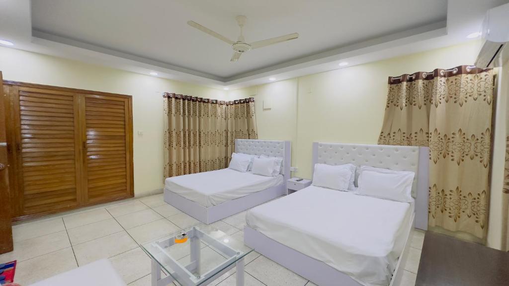 - un salon avec deux lits et une fenêtre dans l'établissement Hotel Blue Sky Inn Banani, à Dhaka