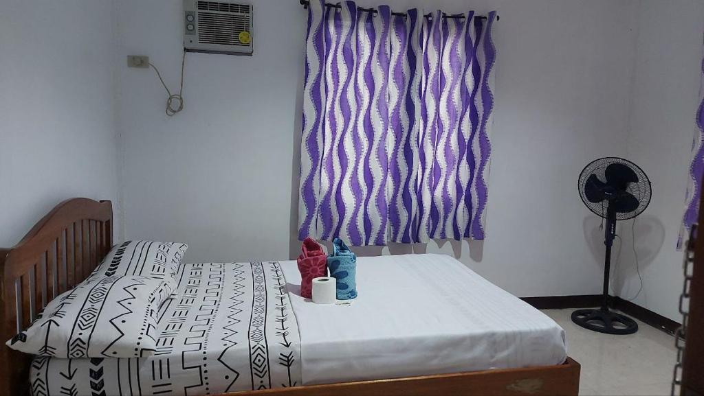 een klein bed in een slaapkamer met een raam bij YZRAJ Homestay in El Nido