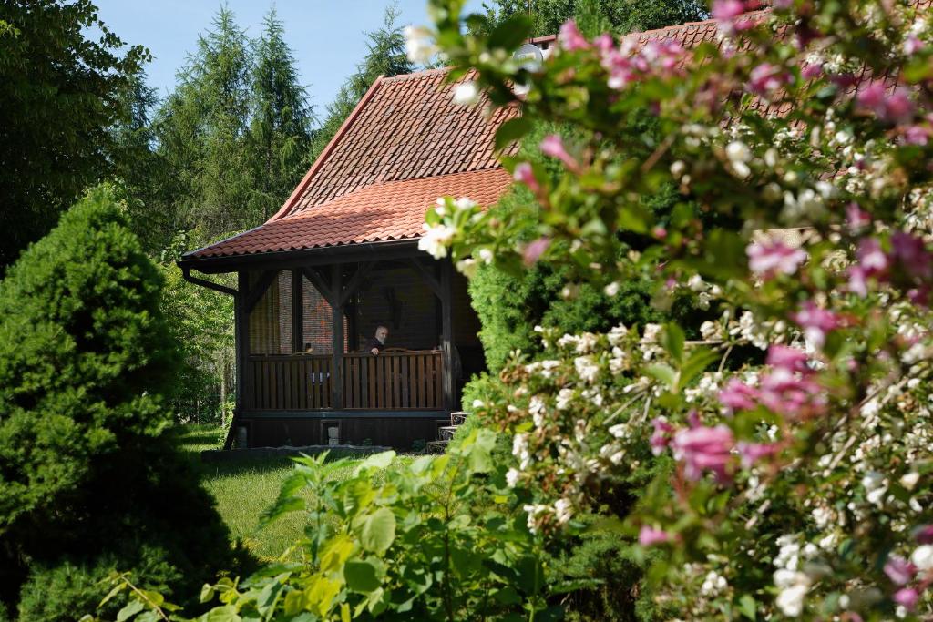 a person sitting in a gazebo in a garden at Siedlisko Otulenie in Bartoszyce