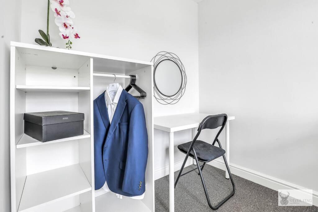 a blue jacket and a chair in a closet at Silver Stag Properties, 4 BR Gem in Coalville in Coalville