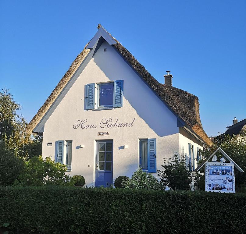 a white house with a thatched roof at Ferienhaus-Seehund in Glowe