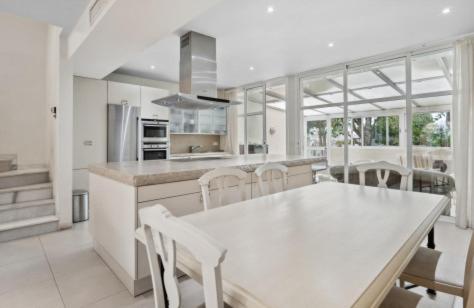 a white kitchen with a white table and chairs at Duplex en Marbella Real in Marbella